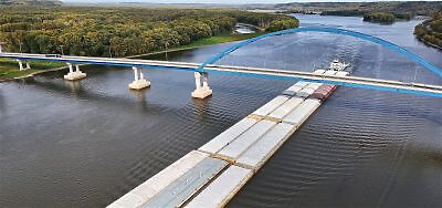 Mississippi river boat pushing cargo under a bridge